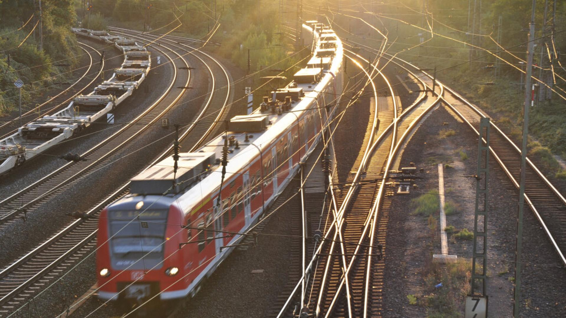 S-Bahn bei Hannover vor Sonne und Güterzug